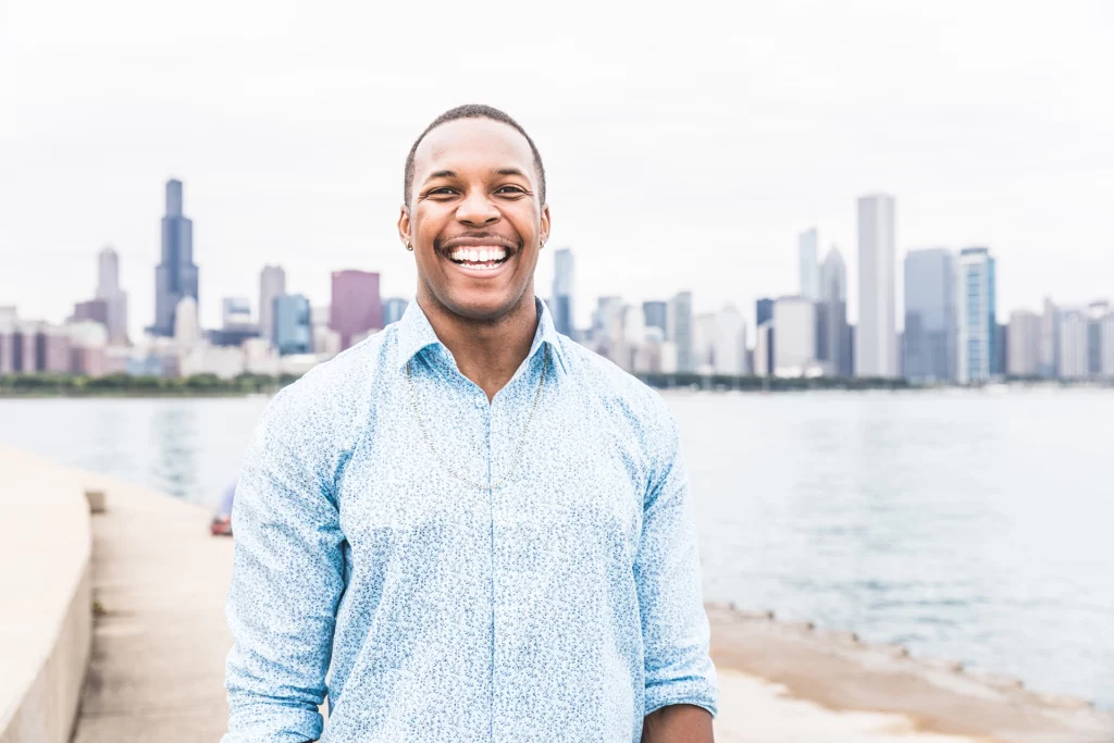Portrait of happy black man laughing out loud in Chicago. Young man looking at camera with Chicago skyline on background. Happiness and lifestyle concepts.